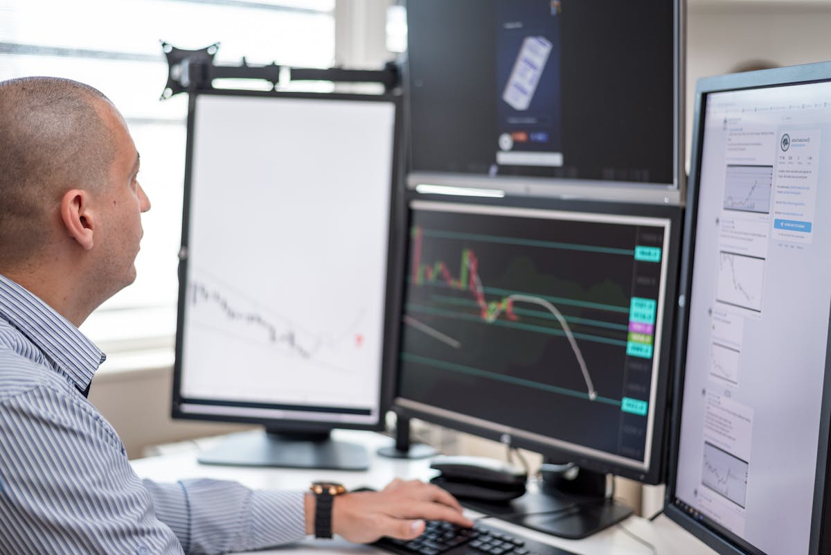 Trader monitoring multiple financial chart screens